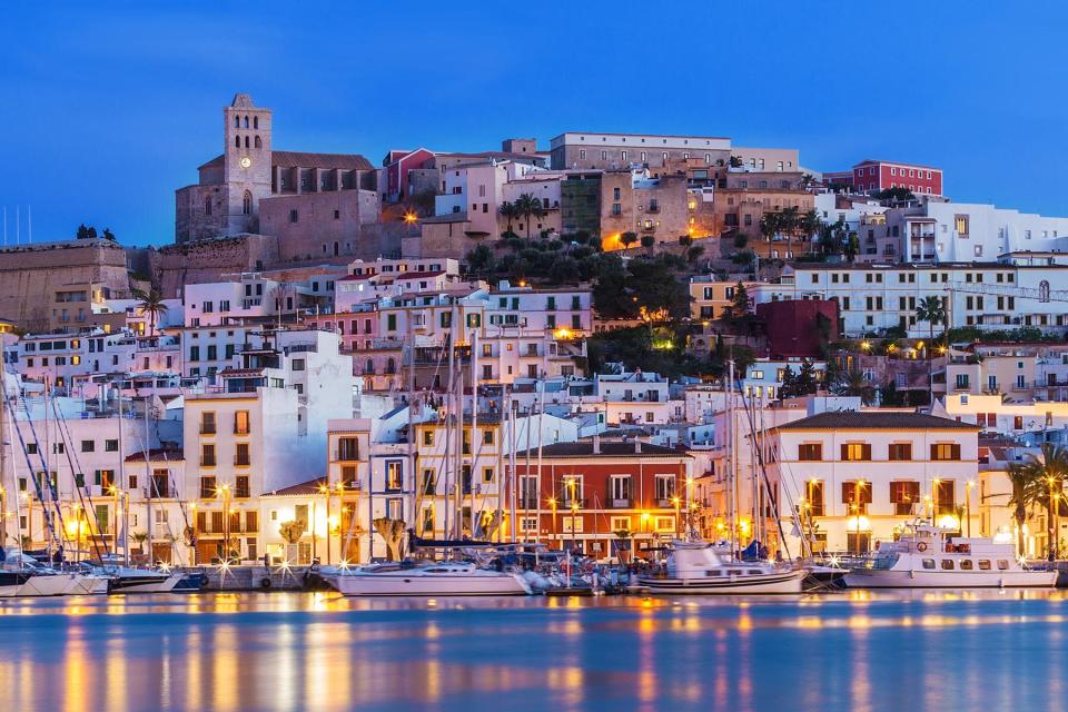 Ibiza Dalt Vila downtown at night with light reflections in the water, Ibiza, Spain.