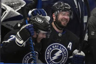 Tampa Bay Lightning right wing Nikita Kucherov, right, celebrates after assisting on a goal by center Brayden Point, left, during the second period of an NHL hockey game Wednesday, April 17, 2024, in Tampa, Fla. The assist was Kucherov's 100th of the season. (AP Photo/Chris O'Meara)