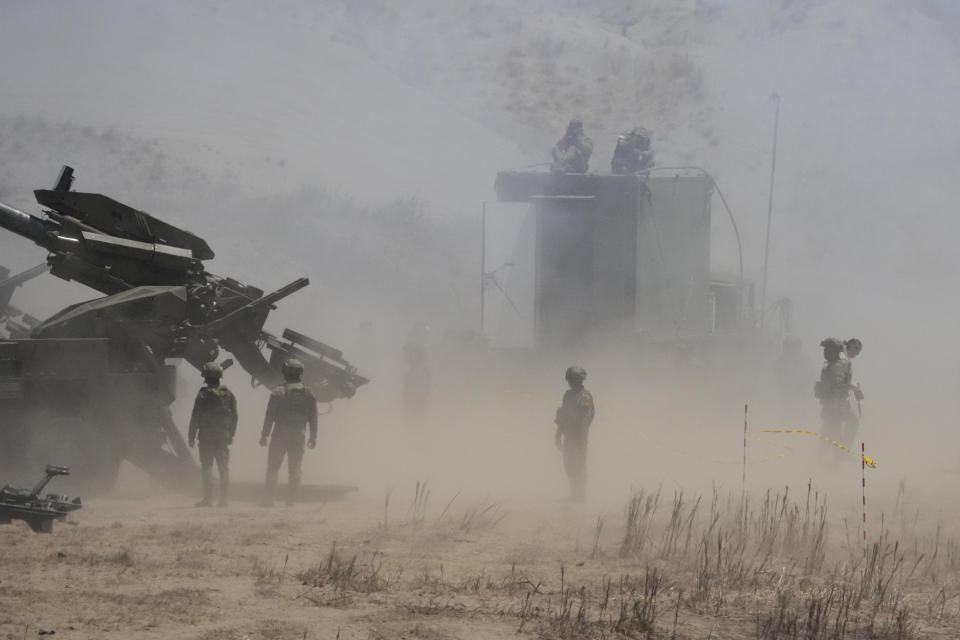 Dust billows as Philippine Army fires ATMOS 155mm howitzers during a joint military exercise on Wednesday, May 8, 2024, in Laoag, Ilocos Norte, northern Philippines. American, Australian and Filipino forces launched a barrage of high-precision rockets, artillery fire and airstrikes to sink a ship Wednesday as part of largescale war drills in waters facing the disputed South China Sea that has antagonized Beijing. (AP Photo/Aaron Favila)