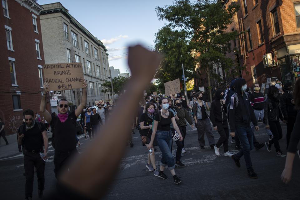 Protesters march down the street during a solidarity rally for George Floyd, Sunday, May 31, 2020, in the Brooklyn borough of New York. Protests were held throughout the city over the death of Floyd, a black man in police custody in Minneapolis who died after being restrained by police officers on Memorial Day. (AP Photo/Wong Maye-E)