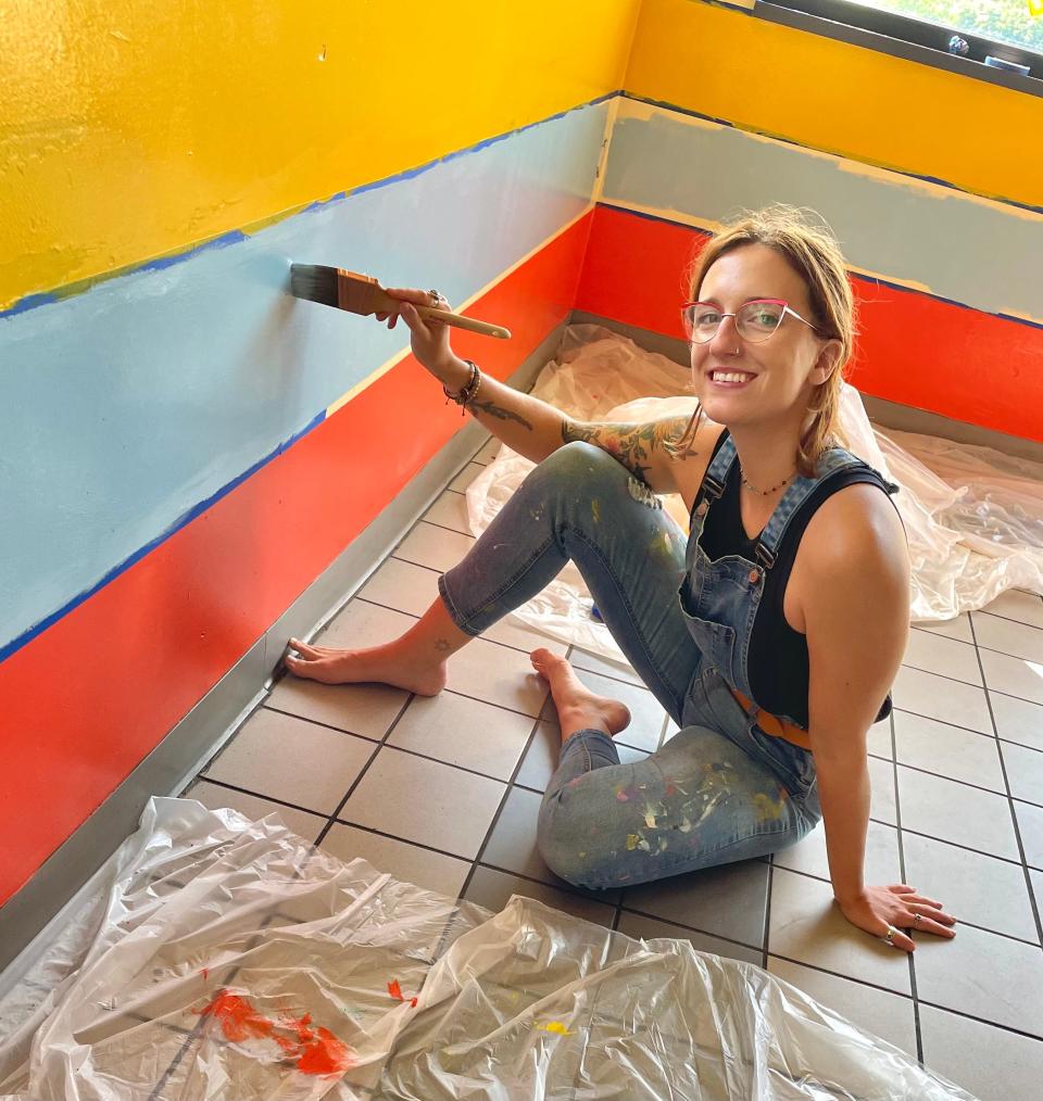 Adrienne Luther paints inside Cafe Berlin in spring 2021.