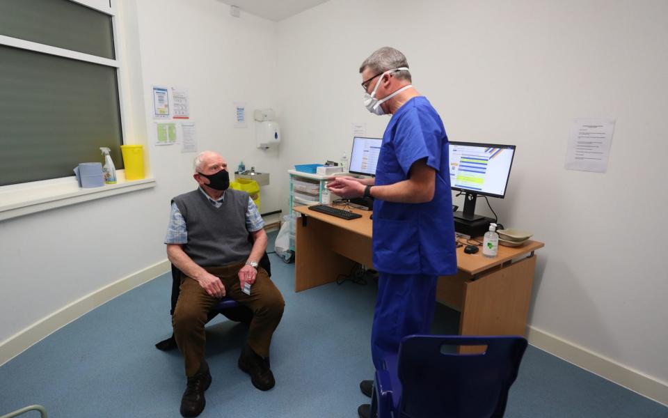 Pharmacist Andrew Hodgson speaks to Robert Salt, 82, before he receives a vaccine at Andrews Pharmacy in Macclesfield, Cheshire - Peter Byrne /PA