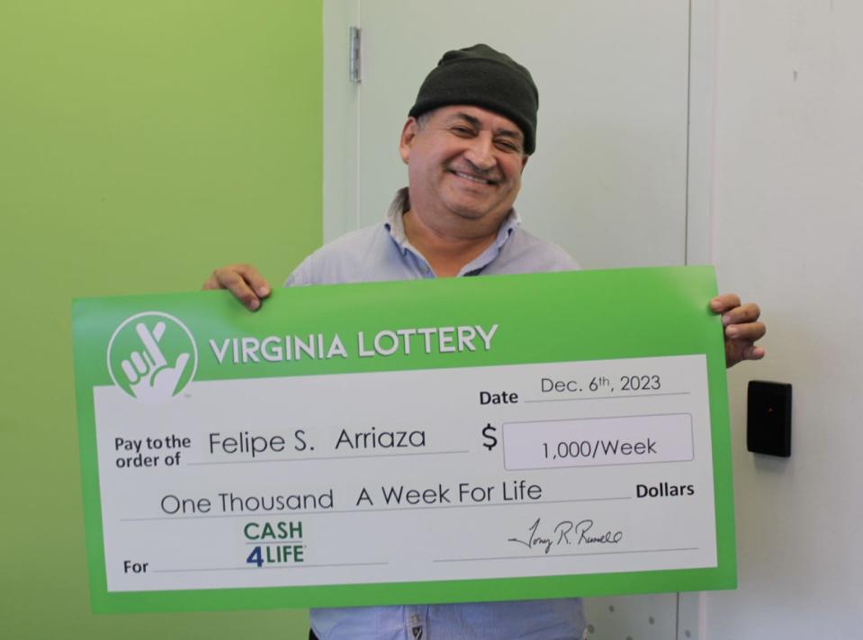 Felipe Arriaza holding his $1,000 a week for life check.