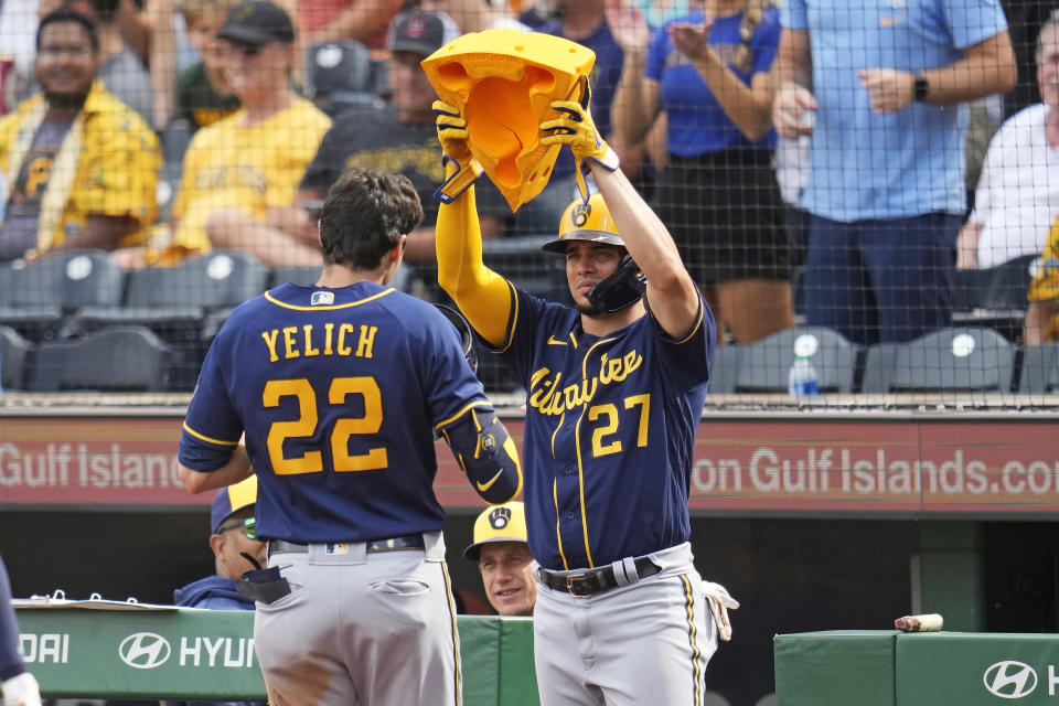 Milwaukee Brewers' Christian Yelich (22) is greeted at the dugout steps by Willy Adames (27) after hitting a three-run home run off Pittsburgh Pirates starting pitcher Johan Oviedo during the second inning of a baseball game in Pittsburgh, Saturday, July 1, 2023. (AP Photo/Gene J. Puskar)