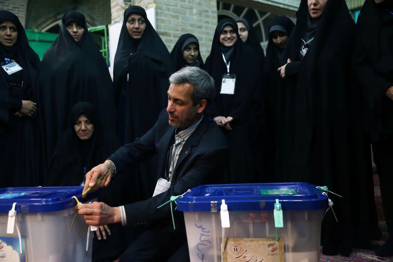 A poll worker opens a ballot box after the parliamentary election voting time ended in Tehran