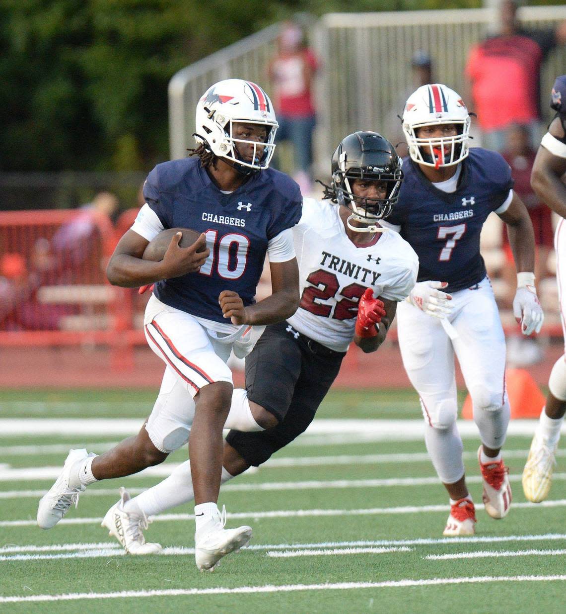 Providence Day quarterback #10, Zaid Lott, runs the ball under pressure in the first half Friday against Trinity Christian. Providence Day lead Trinity Christian 24-0 with 2:30 left in the first half. The Trinity Christian Crusaders came to Charlotte from Fayetteville, N.C. to face off against the nationally ranked Providence Day School Chargers in the first game of the high school football season on Friday, August 16, 2024.