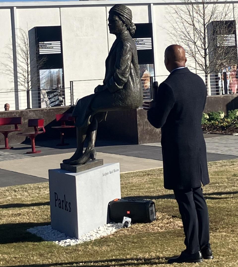 Bryan Stevenson, the founder and executive director of the Equal Justice Initiative, applauds the unveiling of the Rosa Parks statue.