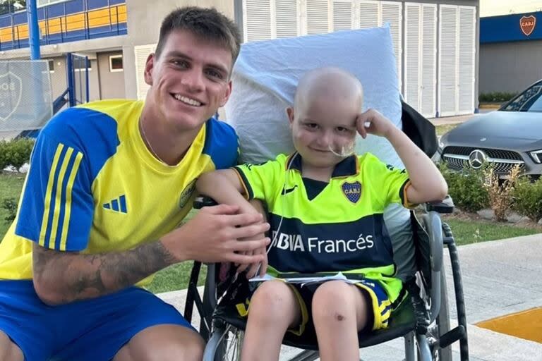 El pequeño Deymar junto a Kevin Zenón, en el predio de Boca; el nene la había dado al jugador un sticker que se puso en una media como amuleto de la suerte