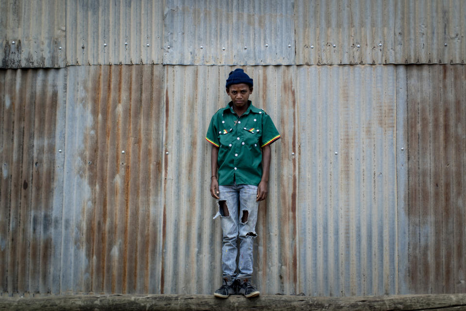 Gebremedhin Gebreslassie, 12, who fled from fighting in the town of Hawzen, stands next to a metal shack at a reception center for the internally displaced in Mekele, in the Tigray region of northern Ethiopia, on Sunday, May 9, 2021. Residents of Hawzen, a town of a few thousand people, said it had seen fighting four times since November. (AP Photo/Ben Curtis)