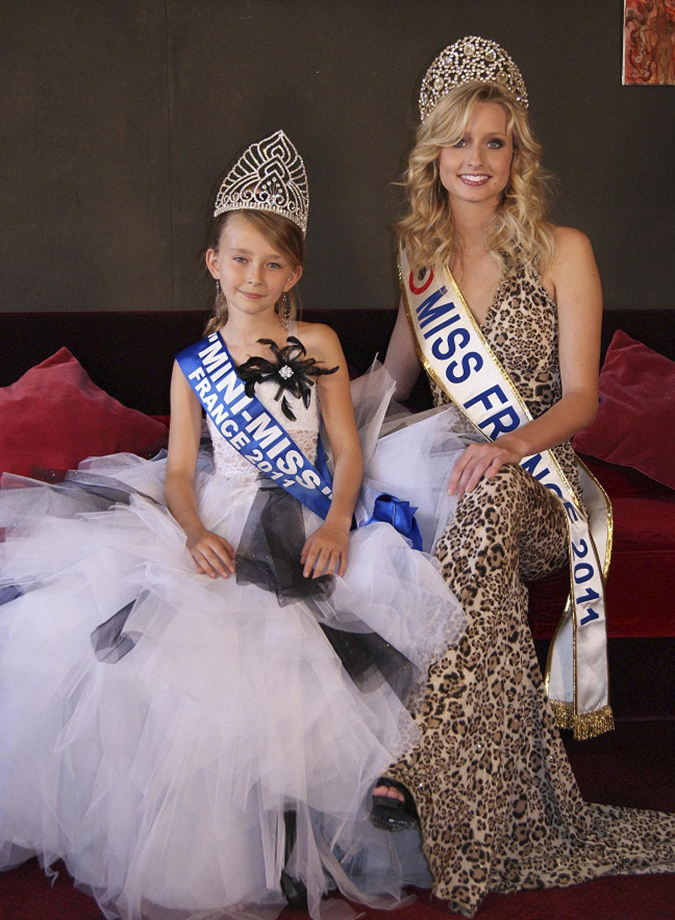 This undated photo provided by the Mini Miss committee shows Oceane Scharre, 10, elected Mini Miss France 2011, left, and Miss France 2011 Mathilde Florin. France's Senate voted Tuesday night, Sept. 17, 2013, to ban beauty pageants for children under 16, in an effort to protect children — especially girls — from being sexualized too early. Anyone who enters a child into such a contest would face up to two years in prison and 30,000 euros in fines, according to the measure. (AP Photo/Mini Miss Committee) FRANCE OUT