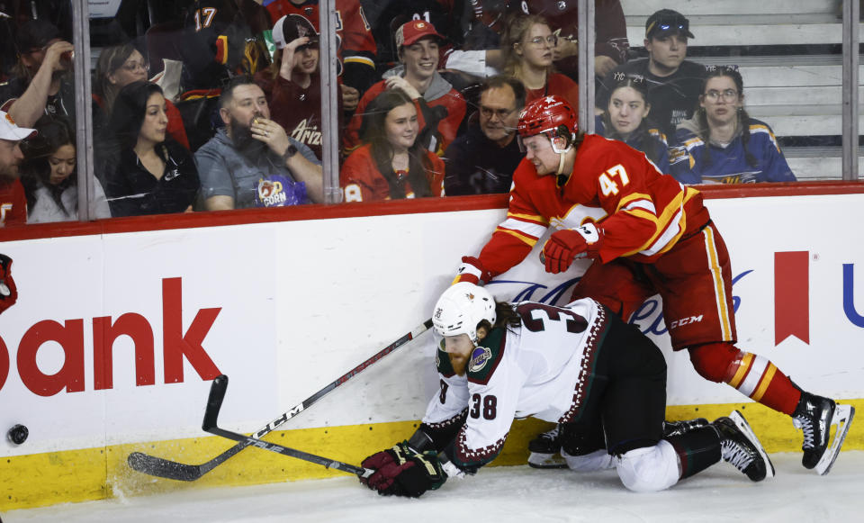 Arizona Coyotes forward Liam O'Brien (38) is checked by Calgary Flames forward Connor Zary (47) during the third period of an NHL hockey game in Calgary, Alberta, Sunday, April 14, 2024. (Jeff McIntosh/The Canadian Press via AP)
