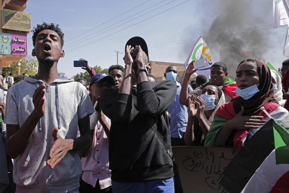 People chant slogans during a protest to denounce the October military coup, in Khartoum, Sudan, Saturday, Dec. 25, 2021. Sudanese security forces fired tear gas to disperse protesters as thousands rallied since earlier in the day, even as authorities tightened security across Khartoum, deploying troops and closing all bridges over the Nile River linking the capital with its twin city of Omdurman and the district of Bahri, the state-run SUNA news agency reported.(AP Photo/Marwan Ali)