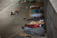 Migrants who are seeking seasonal work harvesting fruit, sleep on the ground in a square in Lleida, Spain, Thursday, July 2, 2020. Authorities in northeast Spain have ordered the lockdown of a county around the city of Lleida due to worrying outbreaks of the COVID-19 virus. Catalan regional authorities announced Saturday, July 4, 2020 that as of noon local time movement will be restricted to and from the county of El Segriá around Lleida which is home to over 200,000 people. Residents will have until 4 p.m. to enter the area. The new outbreaks are linked to agricultural workers in the rural area. (AP Photo/Emilio Morenatti)