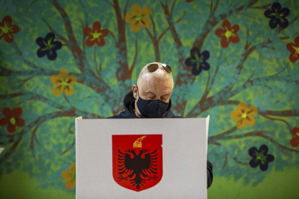 An Albanian man casts his vote during parliamentary elections in capital Tirana, Albania, Sunday, April 25, 2021. Albanian voters have started casting ballots in parliamentary elections on Sunday amid the virus pandemic and a bitter political rivalry between the country's two largest political parties. (AP Photo/Visar Kryeziu)