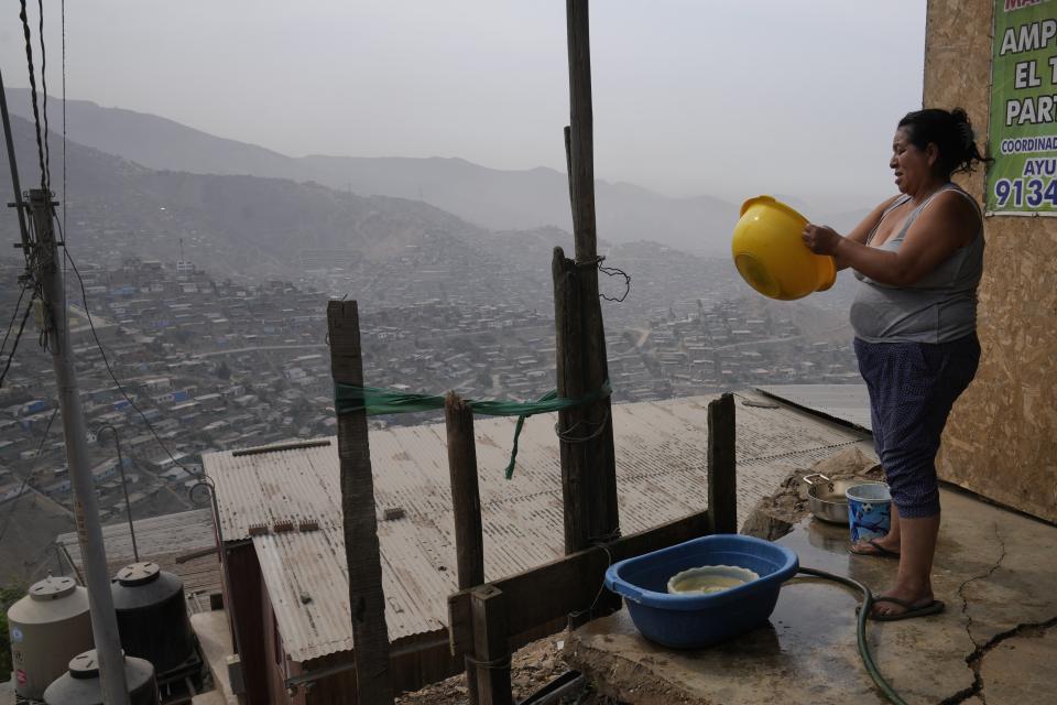 Justina Flores washes her dishes outside of her home in the Pamplona Alta area in Lima, Peru, Thursday, March 7, 2024. Peru’s government gives potable water to 1.5 million of its poorest residents, like Flores, living in the hills. (AP Photo/Martin Mejia)