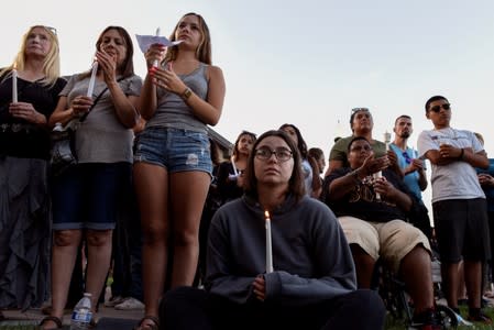 Community members hold candles during a vigil outside of Gilroy City Hall for the victims of a mass shooting at the Gilroy Garlic Festival