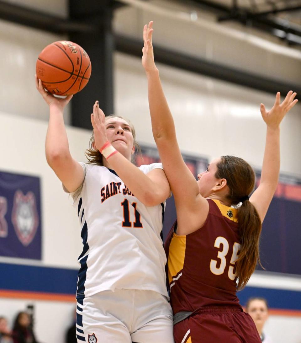 Saint Joseph’s Aubrey Yartz makes a basket over Millersburg defender Emma Miller during the game on Wednesday, Jan. 17, 2024.