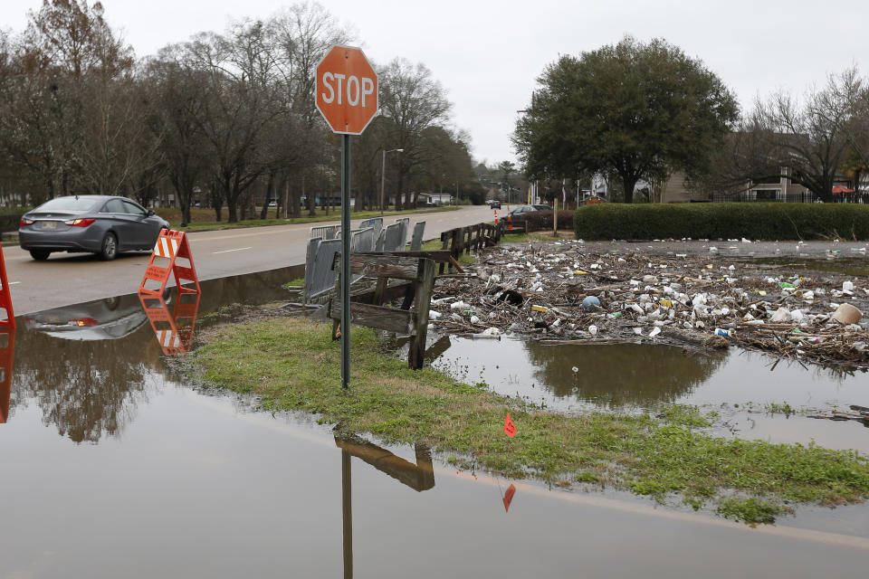 Trash and debris from the Pearl River floodwaters clog part of the Hanging Moss Creek Water in Jackson, Miss., Monday, Feb. 17, 2020. Public officials have warned residents repeatedly from walking through possibly contaminated floodwaters and from allowing their children to play in it. Authorities believe the flooding will rank as third highest, behind the historic floods of 1979 and 1983. (AP Photo/Rogelio V. Solis)