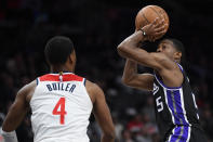 Sacramento Kings guard De'Aaron Fox, right, scores over Washington Wizards guard Jared Butler during the second half of an NBA basketball game Thursday, March 21, 2024, in Washington. (AP Photo/John McDonnell)