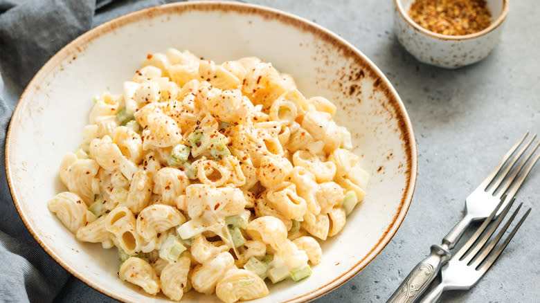 Bowl of macaroni salad next to forks 