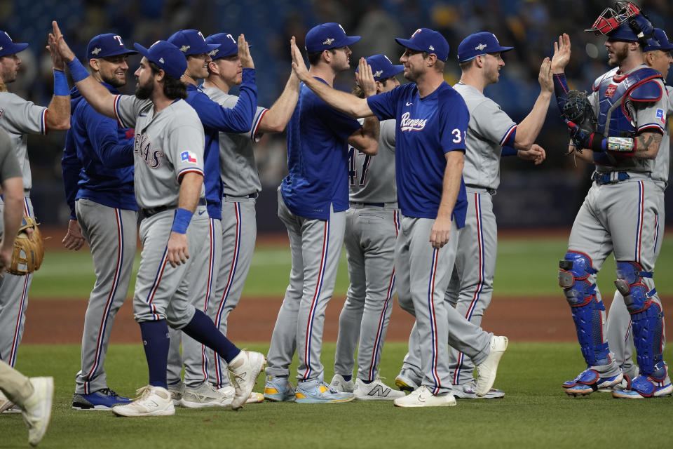 Texas Rangers players celebrate after beating the Tampa Bay Rays 7-1 during Game 2 in an AL wild-card baseball playoff series, Wednesday, Oct. 4, 2023, in St. Petersburg, Fla. (AP Photo/John Raoux)