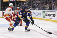 Calgary Flames defenseman Rasmus Andersson (4) pressures St. Louis Blues right wing Vladimir Tarasenko (91) during the second period of an NHL hockey game Thursday, Jan. 27, 2022, in St. Louis. (AP Photo/Joe Puetz)