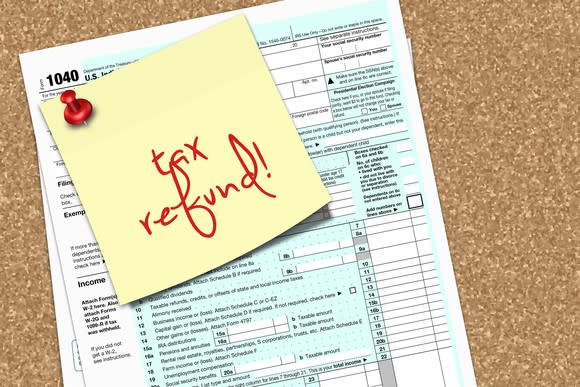 Tax Form 1040 with a note that says tax refund pinned to it