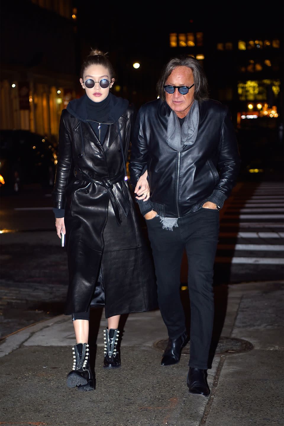 <p>In a navy hooded sweatshirt under a black leather trench coat by Frame with round sunglasses and studded combat boots while out in New York City with her father.</p>