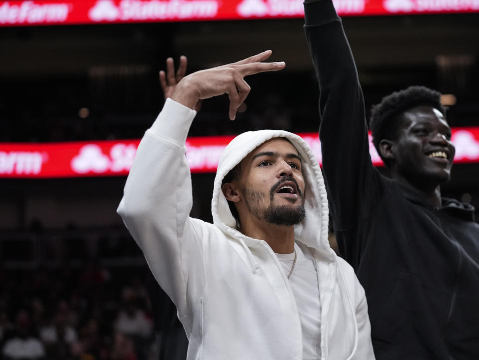 Injured Atlanta Hawks guard Trae Young reacts to a Hawks basket during the first half of an NBA basketball game against the Portland Trail Blazers Wednesday, March 27, 2024, in Atlanta. (AP Photo/John Bazemore)