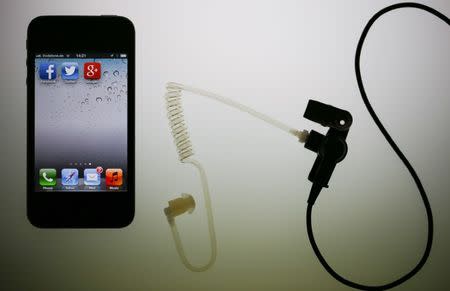 The application icons of Facebook, Twitter and Google are displayed on an iPhone next to an earphone set in this illustration photo taken in Berlin, June 17, 2013. REUTERS/Pawel Kopczynski/Files