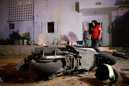 People walk next to the scene where a rocket exploded in the southern city of Sderot, Israel August 8, 2018. REUTERS/Amir Cohen