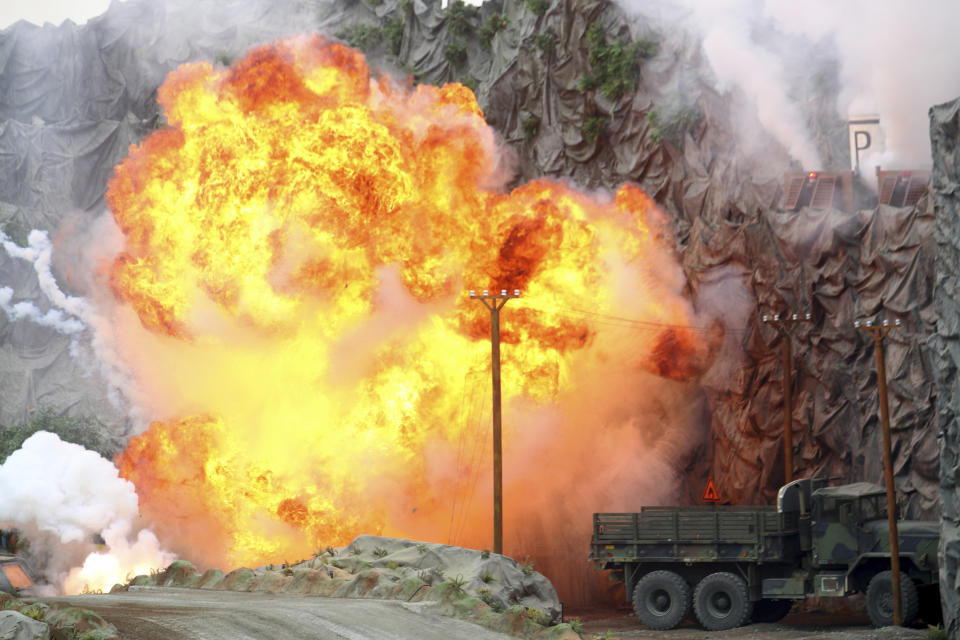 An explosion strikes during a military demonstration targeting a theatrical "ballistic missile launchpad" at the International Defense Exhibition and Conference in Abu Dhabi, United Arab Emirates, Sunday, Feb. 17, 2019. The biennial arms show in Abu Dhabi comes as the United Arab Emirates faces increasing criticism for its role in the yearlong war in Yemen. (AP Photo/Jon Gambrell)