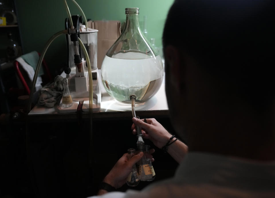 A worker fills up bottles with brandy, inside the distillery in Belgrade, Serbia, Friday, Nov. 11, 2022. The U.N.'s culture and education organization is set later this month to review Serbia's bid to include "social practices and knowledge related to the preparation and use of the traditional plum spirit - sljivovica" on the list of world intangible cultural heritage. (AP Photo/Darko Vojinovic)