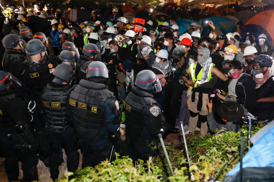 Police face-off with pro-Palestinian students after destroying part of the encampment barricade on the campus of the University of California, Los Angeles (UCLA) in Los Angeles, California, early on May 2, 2024. (Photo by ETIENNE LAURENT/AFP via Getty Images)