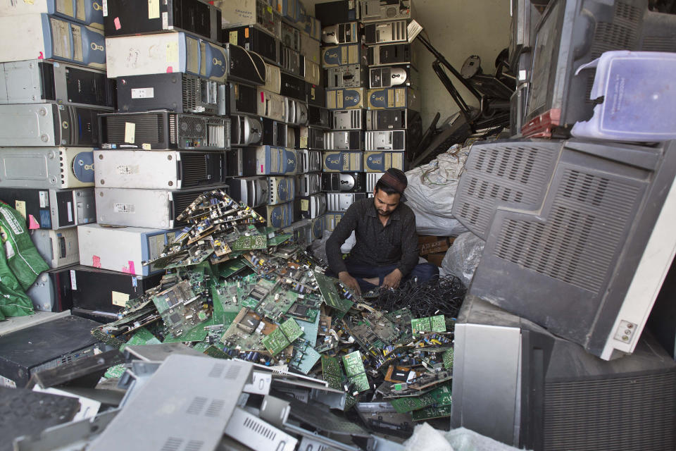 FILE - An Indian man works at a electronic waste recycling shop on World Environment Day in Gauhati, Assam state, India, Monday, June 5, 2017. U.N. agencies warn that electrical waste — everything from discarded refrigerators to TVs to e-scooters to mobile phones — is piling up worldwide, and recycling rates are low and likely to fall even further. (AP Photo/ Anupam Nath, File)