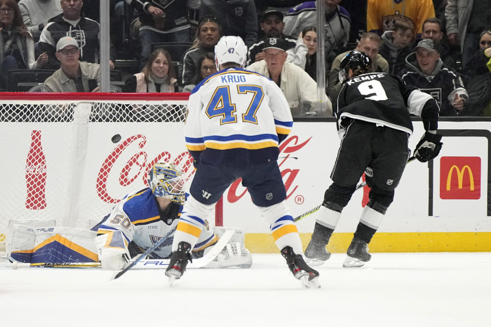 Los Angeles Kings center Adrian Kempe, right, scores on St. Louis Blues goaltender Jordan Binnington, left, as defenseman Torey Krug watches during the first period of an NHL hockey game Saturday, Nov. 18, 2023, in Los Angeles. (AP Photo/Mark J. Terrill)