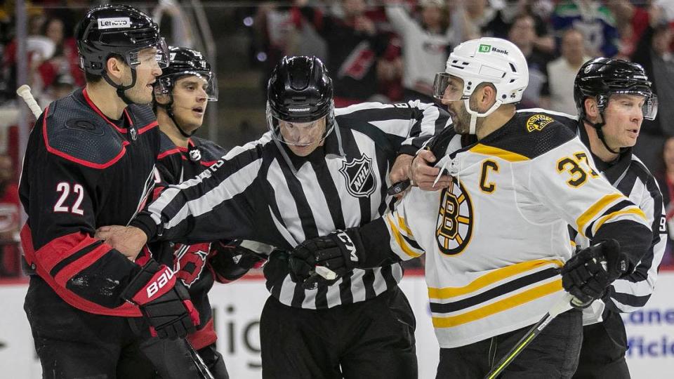 Officials separate Carolina Hurricanes&#xed; Brett Pesce (22) and Boston Bruins&#xed; Patrice Bergeron (37) in the first period on Wednesday, May 4, 2022 during game two of their Stanley Cup first round series at PNC Arena in Raleigh, N.C.