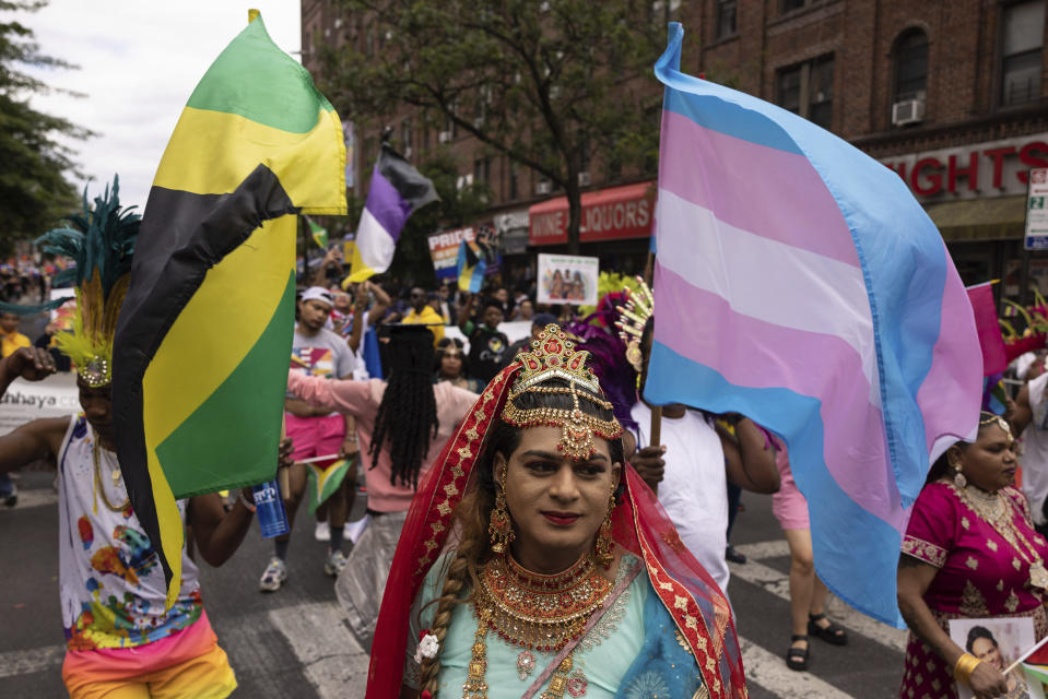 Performers wave a transgender flag, right, and others during the 31st annual Queens Pride Parade and Multicultural Festival, Sunday, June. 4, 2023, in New York. The growing number of new laws and policies, including restrictions on gender-affirming care, public bathroom use and participation in sports, have prompted Pride organizers to more fully embrace a segment of the LGBTQ+ populace that hasn't always felt included in the celebration. (AP Photo/Yuki Iwamura)