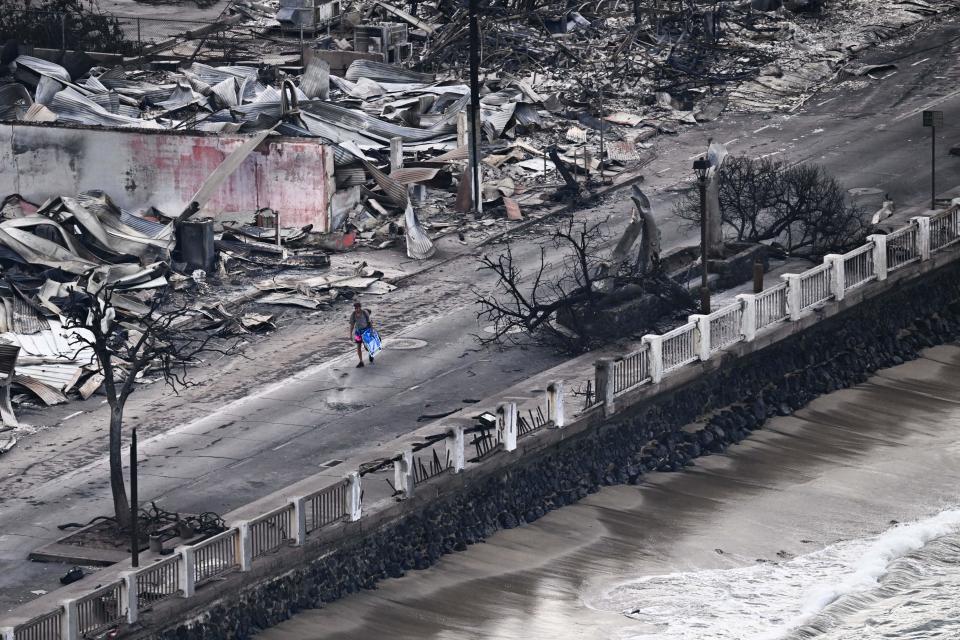 A person was seen walking down Front Street in Lahaina, past destroyed buildings that were burned to the ground. / Credit: PATRICK T. FALLON/AFP via Getty Images
