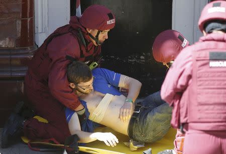 Member of the emergency services tend a casulty during Exercise Strong Tower at the scene of a mock terror attack at a disused underground station in central London, Britain June 30, 2015. REUTERS/Peter Nicholls