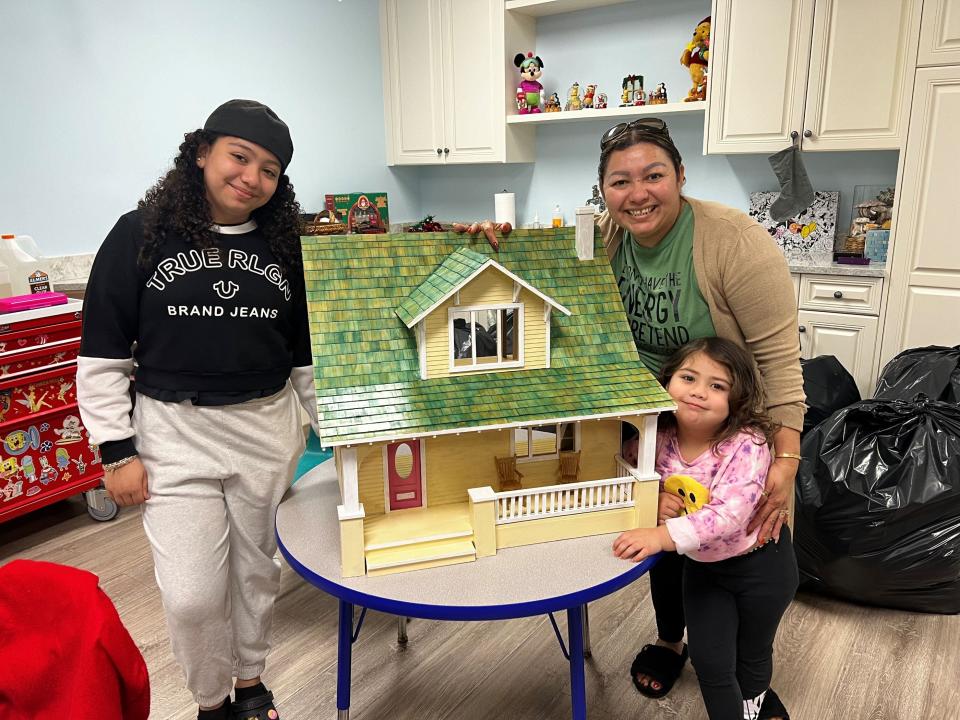 Young cancer patient Amy Galeano, age 4 (bottom right), loves her new dollhouse, a handmade donation from a Season to Share reader. Amy is shown here with her mom Karina and her sister Alondra.