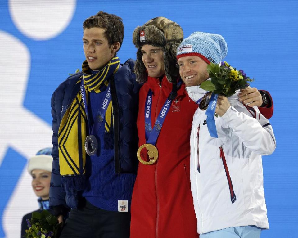 Men's cross-country 30k skiathlon medalists from left, Sweden's Marcus Hellner, silver, Switzerland's Dario Cologna, gold, and Norway's Martin Johnsrud Sundby, bronze, pose during their medals ceremony at the 2014 Winter Olympics, Sunday, Feb. 9, 2014, in Sochi, Russia. (AP Photo/Morry Gash)