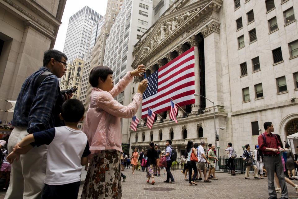 Chinese tourists take photographs outside of the New York Stock Exchange shortly after the opening bell in New York, July 8, 2015.  REUTERS/Lucas Jackson 