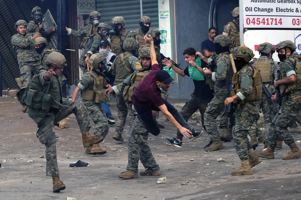 Lebanese army soldiers scuffle with protesters during a demonstration, in solidarity with the Palestinian people in Gaza, near the U.S. Embassy in Aukar, a northern suburb of Beirut, Lebanon, Wednesday, Oct. 18, 2023. (AP Photo/Hassan Ammar)