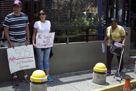 Protesters hold placards during a gathering in demand for medicines in Caracas, Venezuela August 27, 2015. REUTERS/Marco Bello