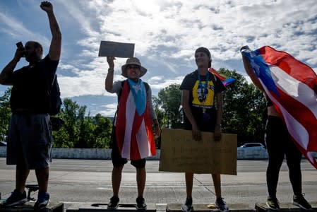 Demonstrators hold banners and flags during the national strike calling for the resignation of Governor Ricardo Rossello in San Juan