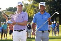 Sep 24, 2017; Atlanta, GA, USA; Justin Thomas hoists the trophy after winning the FedEx Cup with Xander Schauffele holding Calamity Jane a replica of Bobby Jones putter after winning the Tour Championship golf tournament at East Lake Golf Club. Mandatory Credit: Butch Dill-USA TODAY Sports