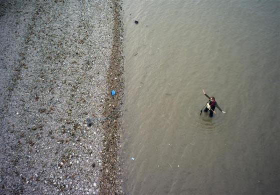 busker plays his electric guitar while standing in the River Thames at low tide along the south bank in London March 13, 2012.