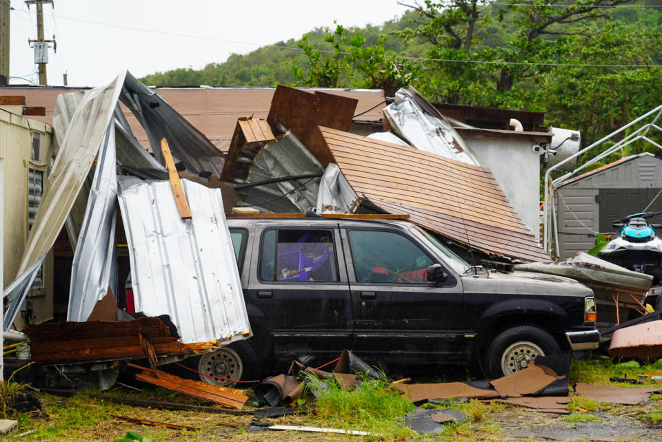 Een SUV bedekt met puin nadat Ernesto Puerto Rico aanreed.