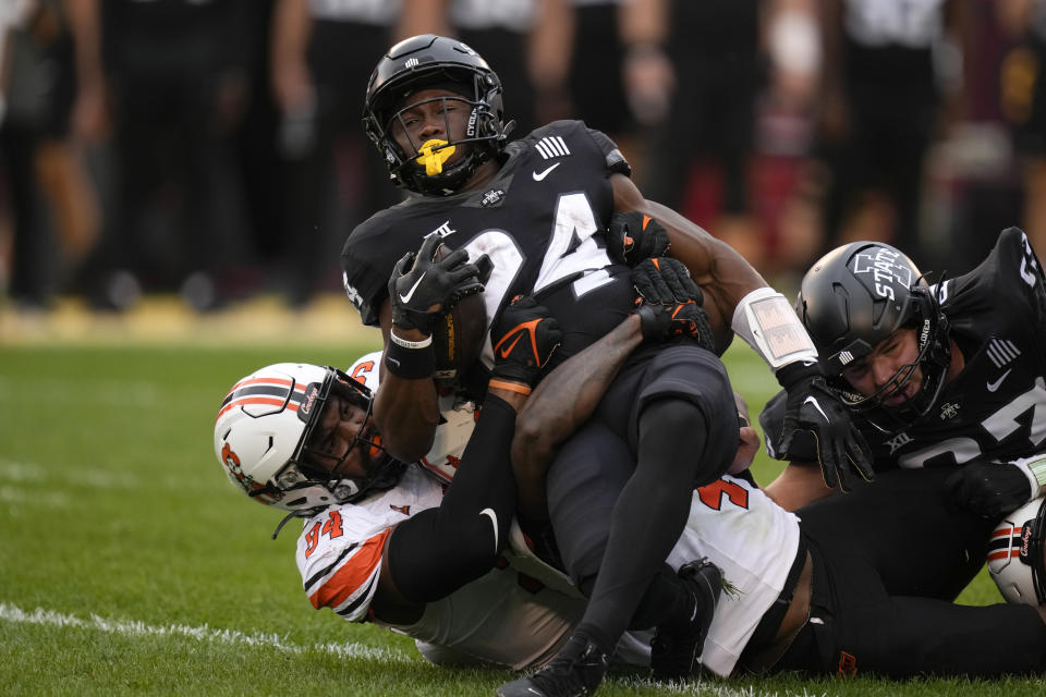 Iowa State running back Abu Sama III (24) is tackled by Oklahoma State nose tackle Marcus Duckworth (54) during the first half of an NCAA college football game, Saturday, Sept. 23, 2023, in Ames, Iowa. (AP Photo/Charlie Neibergall)